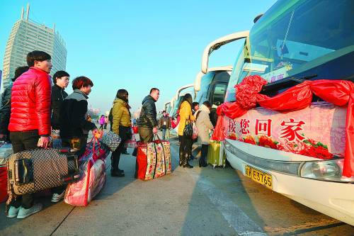 1月22日,在安徽省阜阳火车站,返乡旅客准备登上回家的免费大巴车.