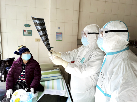 2月17日,医护人员在武汉大学中南医院查看一名新冠肺炎患者的医学